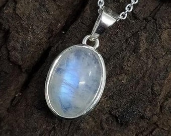 May include: A silver chain necklace with a moonstone pendant. The oval-shaped moonstone is set in silver and has a light blue iridescent sheen.