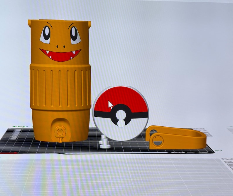 May include: An orange water cooler with a Charmander face design, a red and white Pok&eacute;ball, and a matching orange handle. The cooler has a spigot and vertical ridges. The design is 3D printed.
