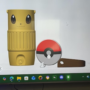 May include: A yellow travel mug with a cartoon face, a red and white Pok&eacute; Ball, and a brown handle. The mug has a cylindrical shape with a ribbed design and a small button. The Pok&eacute; Ball is round with a white center.