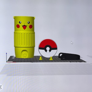 May include: A yellow Pikachu-themed tumbler with a smiling face and red cheeks, a red and white Pokeball, and a black object. The tumbler has a ribbed design and a small circular opening at the bottom. The Pokeball is round with a black center.