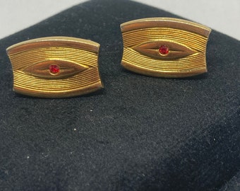 Gemelli vintage color oro con strass rossi.