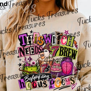 May include: A sand-colored crewneck sweatshirt featuring a colorful graphic print with the text This Witch Needs 7 Brew Before Any Hocus Pocus. The design includes a ghost in a witch hat, a green cauldron, a coffee cup, a cupcake, and a jar with a brain.