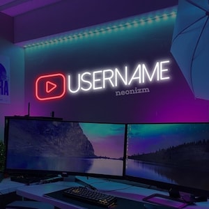 Può includere: Un'insegna al neon a parete con un'icona rossa del pulsante play in stile YouTube accanto al testo bianco "USERNAME" e al testo bianco più piccolo "neonizm" sottostante, illuminata su una parete scura con luce ambientale viola e blu.