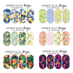 May include: A collection of nail art decals featuring various designs. The top row includes lemon and floral patterns, while the second row showcases lemon and geometric patterns. The bottom row displays tropical fruit and floral designs. The brand name "ANNICK & CO. Designs" is visible.