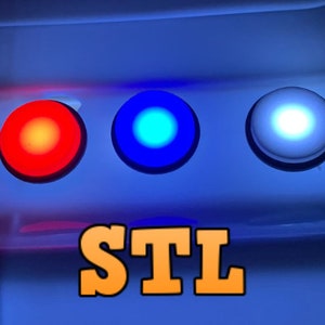 Puede incluir: Tres botones redondos con luces. Los botones son rojo, azul y blanco. El texto "STL" está debajo de los botones.