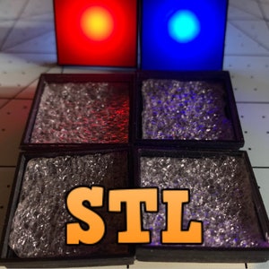 Pode incluir: Quatro bandejas quadradas pretas com uma superfície clara e texturizada. As bandejas estão dispostas em uma grade de 2x2. A palavra "STL" está impressa em laranja no centro da imagem.