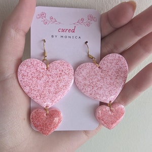 Brincos pendurados com tema de coração, corações duplos, rosa e vermelho, glitter vermelho, brincos extravagantes, dia dos namorados, tema de amor