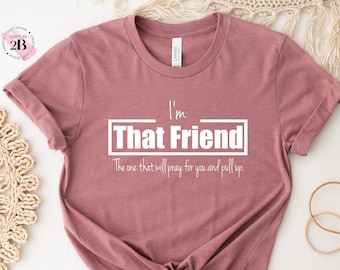 May include: A mauve t-shirt with white text that reads "I'm That Friend. The one that will pray for you and pull up."