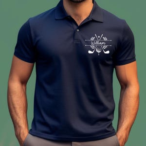 May include: A navy blue polo shirt with a white golf-themed design featuring crossed golf clubs, a golf ball, and the name "William".