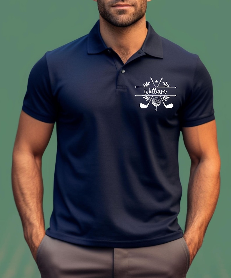 May include: A navy blue polo shirt with a white golf-themed design featuring crossed golf clubs, a golf ball, and the name "William".
