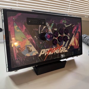 Pu&ograve; includere: Un joystick da arcade nero con un design personalizzato che presenta personaggi anime e il testo "Pro-Am". Il joystick ha otto pulsanti viola e un joystick nero e viola.