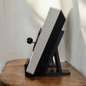 Pu&ograve; includere: Un joystick da arcade bianco e nero con una palla nera in cima, montato su un supporto nero. Il supporto ha una forma triangolare ed &egrave; fatto di plastica.