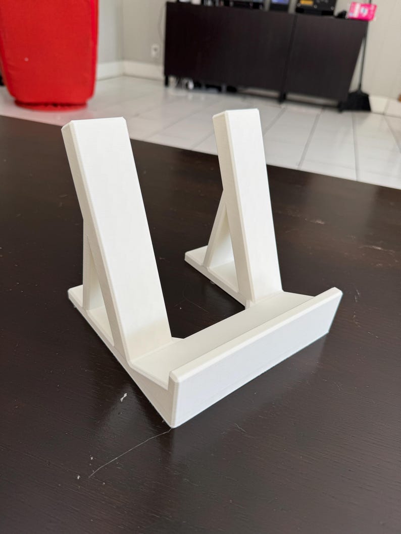 Pu&ograve; includere: Supporto in plastica bianca con due supporti inclinati per tenere un tablet o un libro.