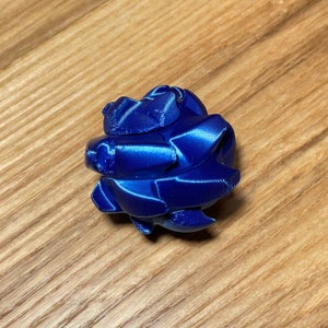 May include: A blue 3D printed object shaped like a rose. The object has a smooth, glossy finish.