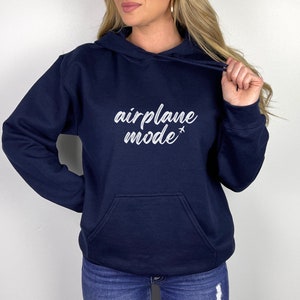May include: Navy blue hoodie with a front pocket and drawstring. The white text "airplane mode" is printed on the front, with a small airplane graphic. A casual, comfortable sweatshirt for everyday wear.