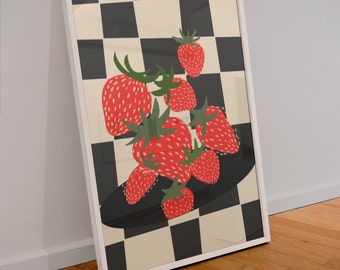 Puede incluir: Una lámina de arte enmarcada que muestra un grupo de fresas rojas con tallos y hojas verdes dispuestas sobre una forma ovalada negra. El fondo consiste en un patrón de tablero de ajedrez de ajedrez en negro y crema. El marco es de color blanco.