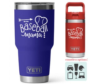 May include: A blue YETI tumbler with a white design that says "Baseball Mama" with a baseball and arrow. A red YETI Rambler with the same design is shown next to it.  The image also shows a variety of other designs that can be added to the tumblers.