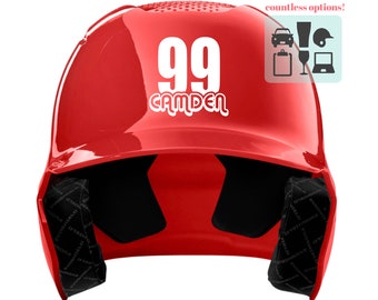 May include: A red baseball helmet with the number "99" and the name "CAMDEN" in white lettering. The helmet has black padding inside and a small graphic with icons. The helmet is designed to protect the head during baseball games.