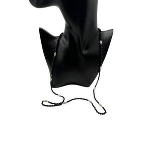 Puede incluir: Un collar largo de cuentas negras con detalles plateados. El collar se muestra en un maniquí negro.