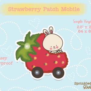 May include: A glossy, waterproof vinyl sticker featuring a cartoon bunny driving a red strawberry car. The sticker is 2.5 inches by 2.5 inches and says "Strawberry Patch Mobile" at the top.