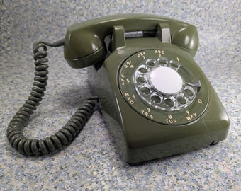 Teléfono fijo antiguo de disco giratorio verde en funcionamiento - Modelo 500 de Northern Electric - Presenta algunos daños
