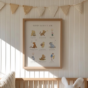 May include: A Winnie the Pooh themed nursery decor print with the text "God Says I Am" and a list of positive affirmations. The print is framed in a light brown wood frame and is hanging on a white wall with a white wood paneling.