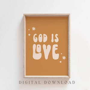 May include: A framed print with the words "GOD IS LOVE" in a retro font on a mustard-colored background. Small white flower and dot accents surround the text. The words "DIGITAL DOWNLOAD" are at the bottom.