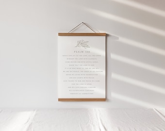 May include: A white canvas print with the text of Psalm 100 in black, displayed on a wooden frame with a hanging cord. The print features a simple botanical illustration at the top.