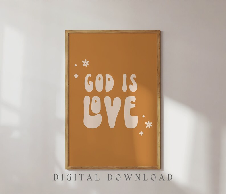 May include: A framed art print with the words "GOD IS LOVE" in a retro font, set against a warm orange background. The print includes small floral accents and the text "DIGITAL DOWNLOAD" at the bottom.
