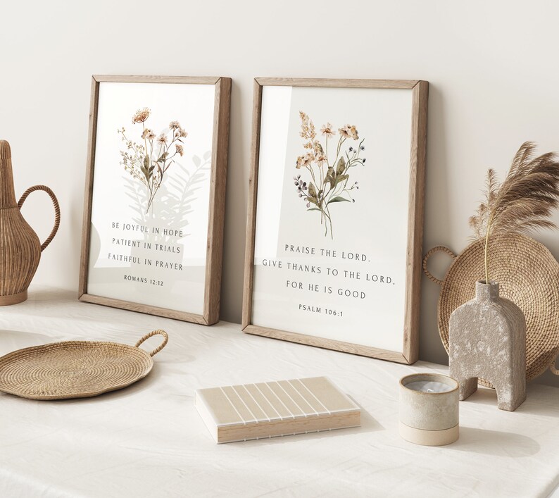 May include: Two framed art prints with botanical illustrations and inspirational quotes. The left print reads "Be Joyful in Hope, Patient in Trials, Faithful in Prayer, Romans 12:12." The right print reads "Praise the Lord, Give Thanks to the Lord, For He is Good, Psalm 106:1."