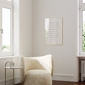 May include: A white armchair with a gold frame around a framed print with the text "Trust in the Lord with all your heart and lean not on your own understanding: In all your ways submit to him, and he will make your paths straight. Proverbs 3:5-6."