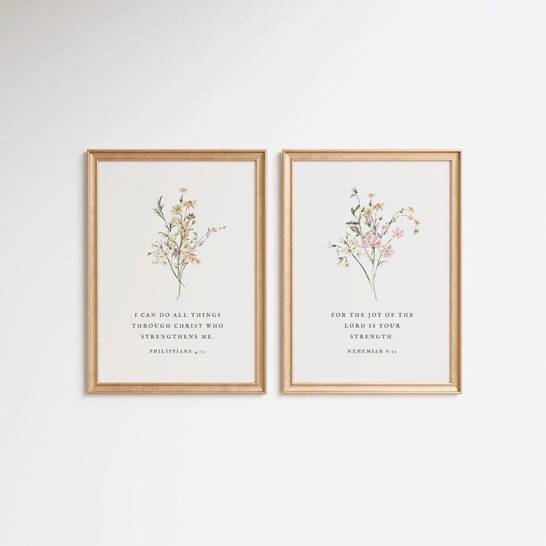May include: Two framed art prints with gold frames. Each print features a floral watercolor design with text. One reads "I CAN DO ALL THINGS THROUGH CHRIST WHO STRENGTHENS ME. PHILIPPIANS 4:13." The other reads "FOR THE JOY OF THE LORD IS YOUR STRENGTH. NEHEMIAH 8:10."