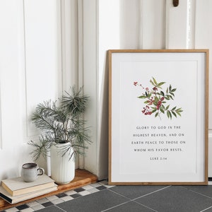 May include: A framed print with a watercolor illustration of a green plant with red berries. The print features the text "Glory to God in the highest heaven, and on earth peace to those on whom his favor rests. Luke 2:14".
