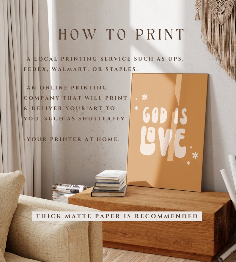 May include: A framed print with the words "GOD IS LOVE" in white on a mustard-colored background. The print is displayed on a wooden table, with text above that reads "HOW TO PRINT". The text below the print says "THICK MATTE PAPER IS RECOMMENDED".