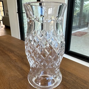 May include: A clear glass vase featuring a flared rim and a tapered base. The body of the vase is decorated with a prominent diamond-shaped cut pattern that covers the midsection, creating a textured, faceted appearance throughout the glass surface.
