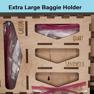 May include: Wooden organizer with four compartments for storing plastic bags. The compartments are labeled "Gallon", "Quart", "Sandwich", and "Snack".