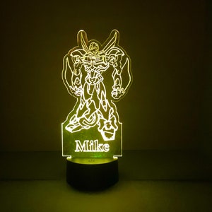 May include: A green and yellow 3D printed night light with a robot design and the name "Mike" printed on the base.