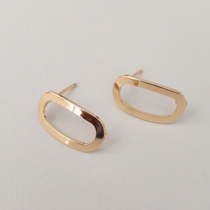 May include: A pair of gold oval-shaped earrings with a hollow centre.