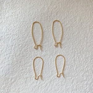 May include: Four gold-colored earring hooks, each with a loop at the top and a small hook at the bottom.