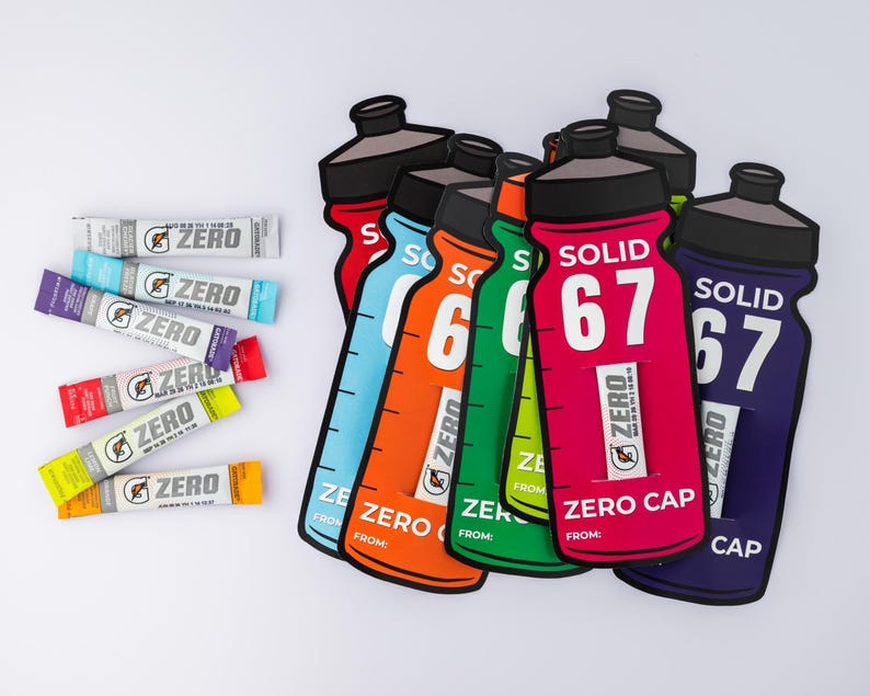 May include: A selection of vibrant water bottle-shaped cutouts and sports drink sachets. The bottles are in shades of red, blue, orange, green, and purple, with "ZERO" and "SOLID 67". The sachets are labelled "ZERO" in different colors.