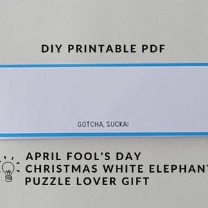 May include: Printable PDF for an April Fool's Day gift. The text reads "Gotcha, Sucka!" and "April Fool's Day Christmas White Elephant Puzzle Lover Gift".