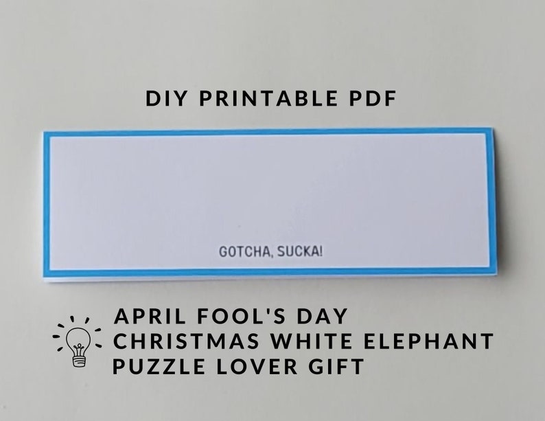 May include: Printable PDF for an April Fool's Day gift. The text reads "Gotcha, Sucka!" and "April Fool's Day Christmas White Elephant Puzzle Lover Gift".