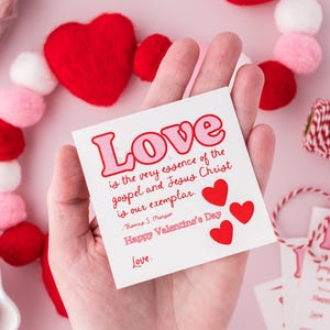 K&ouml;nnte beinhalten: Eine wei&szlig;e Karte mit roten und rosa Herzen und dem Text "Liebe ist die Essenz des Evangeliums und Jesus Christus ist unser Vorbild." -Thomas S. Monson Frohen Valentinstag Liebe.