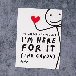 May include: A white Valentine's Day card with a stick figure holding a red heart. The card reads "IT'S VALENTINE'S DAY AND I'M HERE FOR IT (THE CANDY) FROM:" in bold black letters. The background is a textured gray surface.