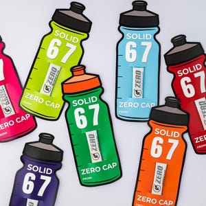May include: A selection of water bottle-shaped cards in various colours. Each card displays the text "SOLID 67" and "ZERO CAP". The colours include pink, green, blue, red, orange, and purple. Each card also has a small insert.