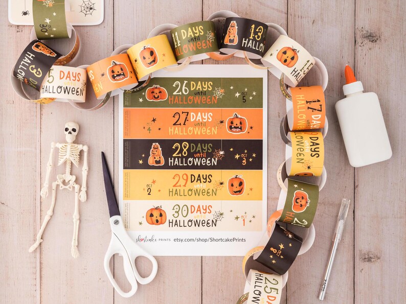 May include: A Halloween countdown chain with orange, black, and white paper circles. Each circle has a pumpkin and the number of days until Halloween. The chain is made of paper and is ready to be assembled.