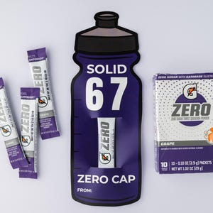 May include: Image of Gatorade Zero products. The composition includes individual packets, a box of grape-flavored powder, and a large purple bottle-shaped display. The box contains 10 packets, each 2.9 grams.