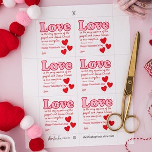 K&ouml;nnte beinhalten: Druckbare Valentinstag-Geschenk-Etiketten in einem rosa und roten Farbschema. Die Etiketten zeigen den Text "Liebe ist die Essenz des Evangeliums und Jesu Christi, er ist unser Vorbild. Frohen Valentinstag."