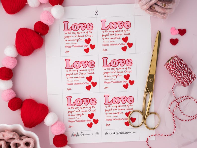 K&ouml;nnte beinhalten: Druckbare Valentinstag-Geschenk-Etiketten in einem rosa und roten Farbschema. Die Etiketten zeigen den Text "Liebe ist die Essenz des Evangeliums und Jesu Christi, er ist unser Vorbild. Frohen Valentinstag."