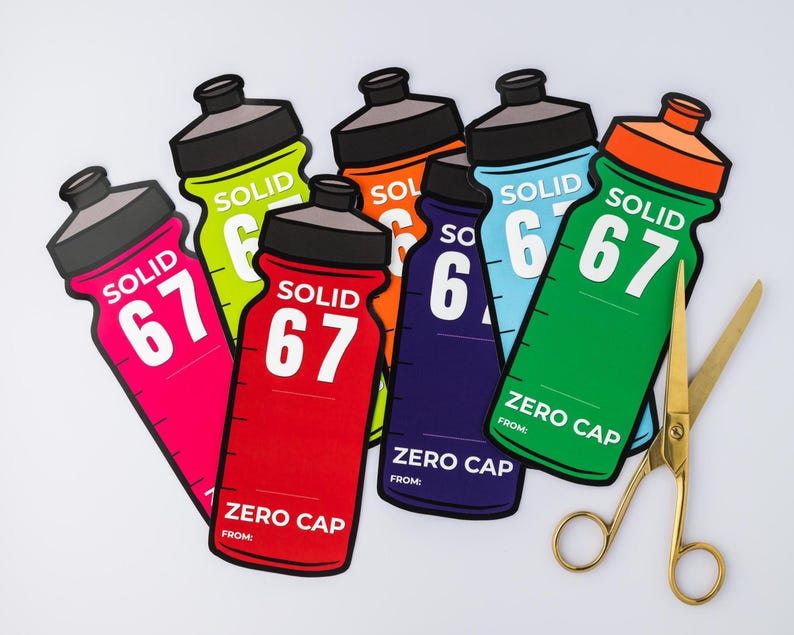 May include: A selection of vibrant water bottle-shaped stickers, each displaying the word "SOLID" and the number "67". The stickers come in various colours: pink, red, orange, green, blue, and yellow. The text "ZERO CAP" is also printed on the stickers.